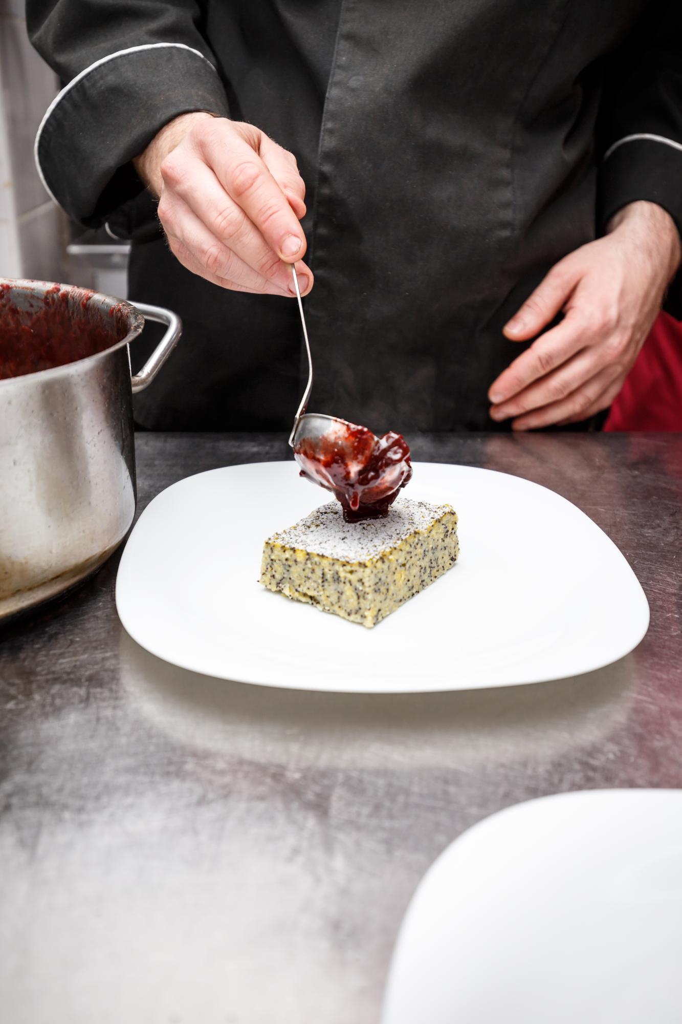 Chef arranging plated dessert on marble